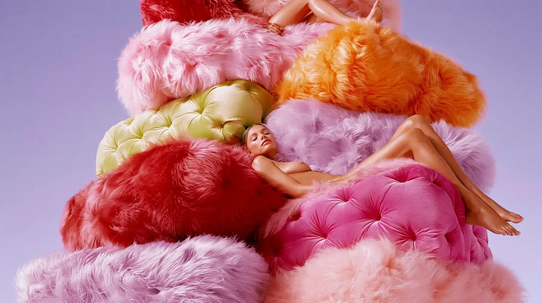 Cover of The Era of Comfort: a figure resting in a tower of faux-fur cushions