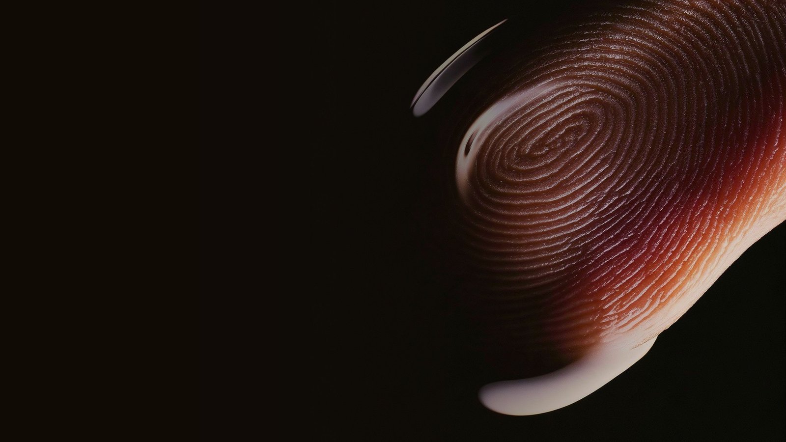 Macro photograph of a fingertip and its print, lit in warm tones